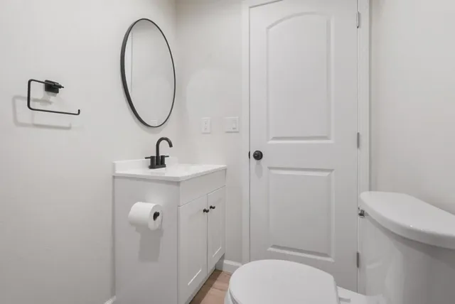 a bathroom with a sink a toilet and a mirror