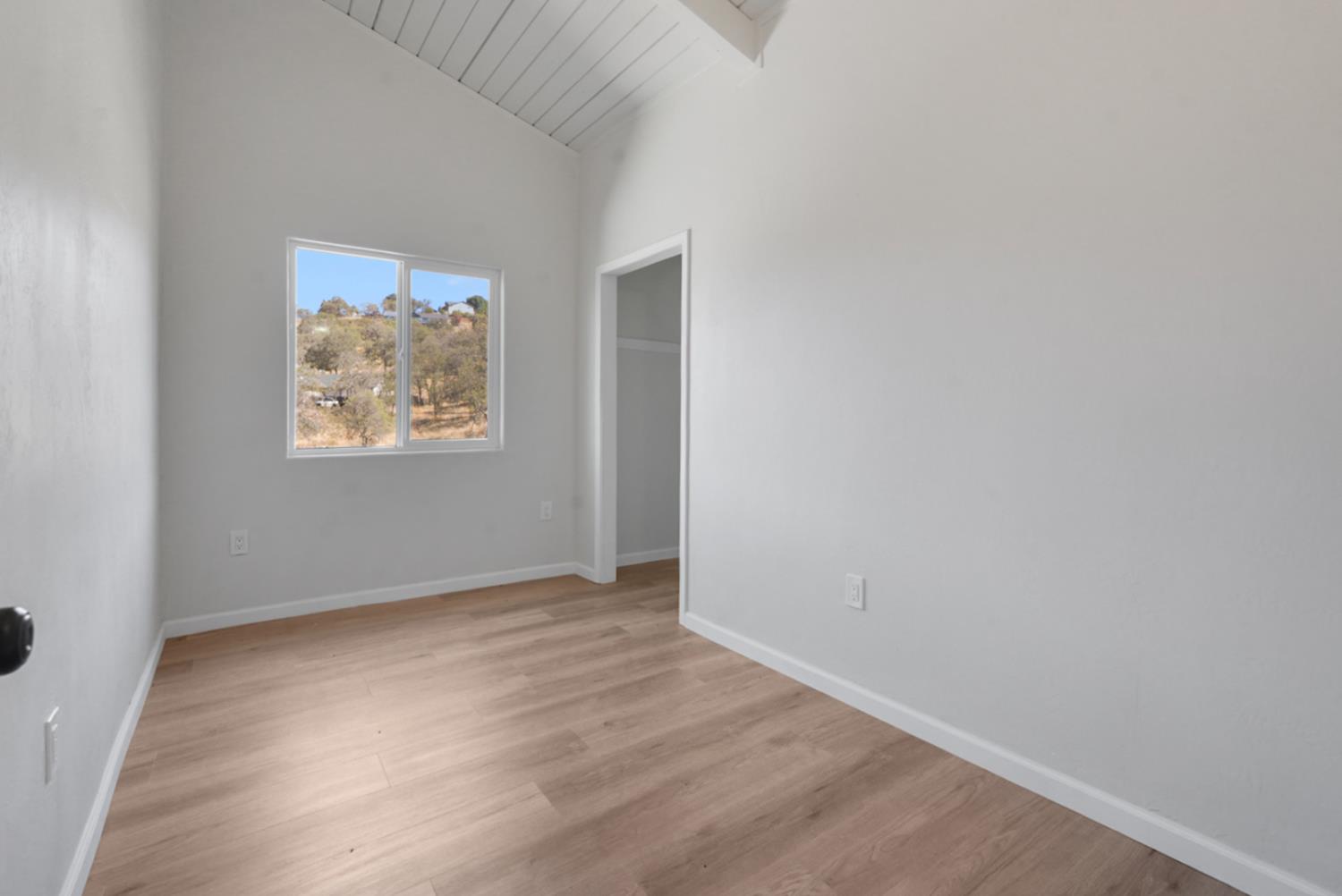 2324 Quail Hill Road Copperopolis, CA 95228 - Photo 21 of 37 a view of an empty room with wooden floor and a window