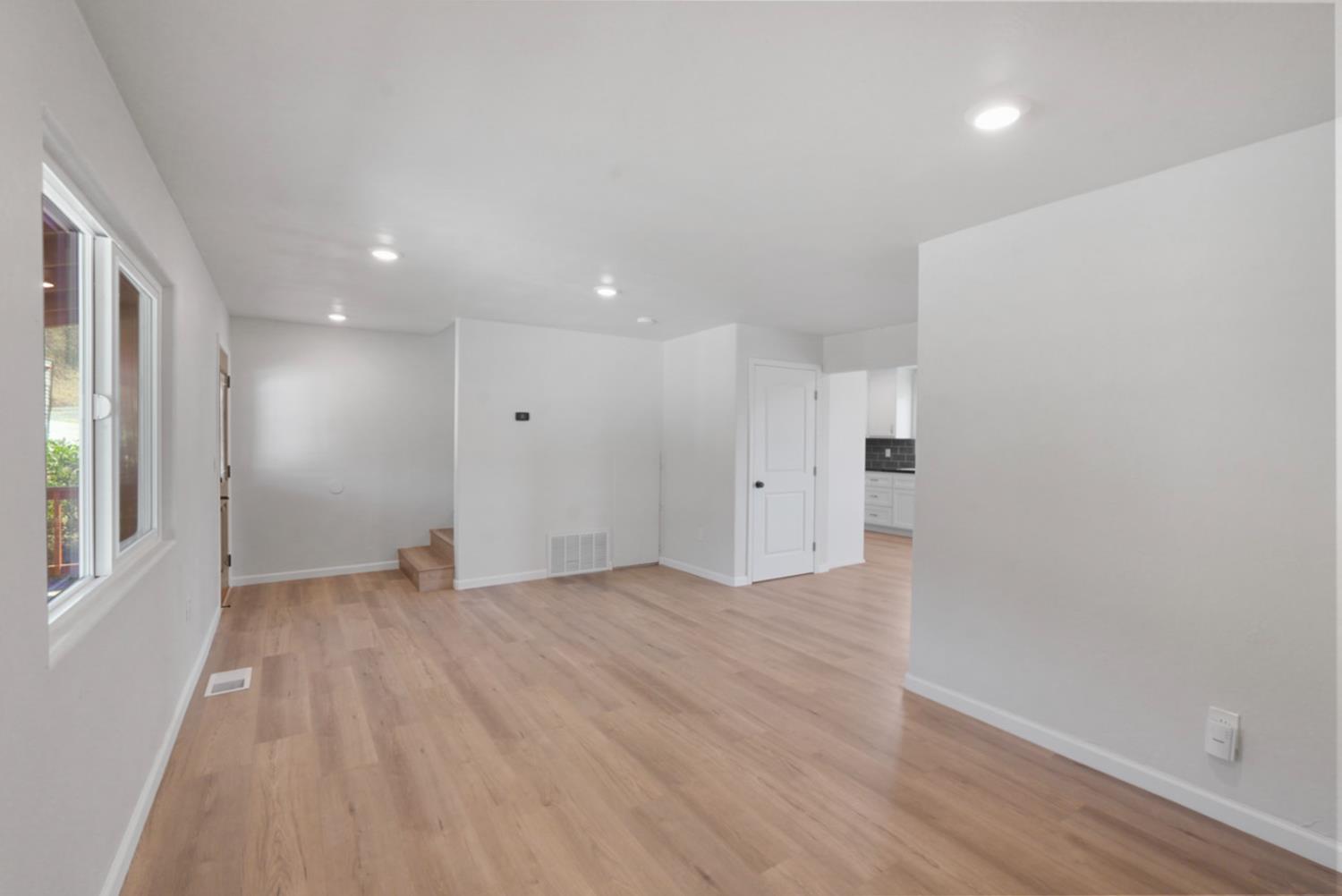 2324 Quail Hill Road Copperopolis, CA 95228 - Photo 7 of 37 a view of an empty room with wooden floor and a window