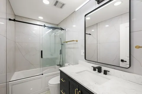 a bathroom with a sink a toilet and shower