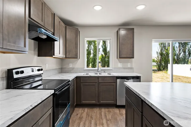 a kitchen with a sink stove top oven and refrigerator