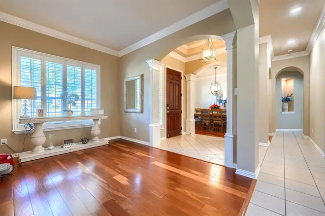 a view of a hallway with wooden floor and a living room