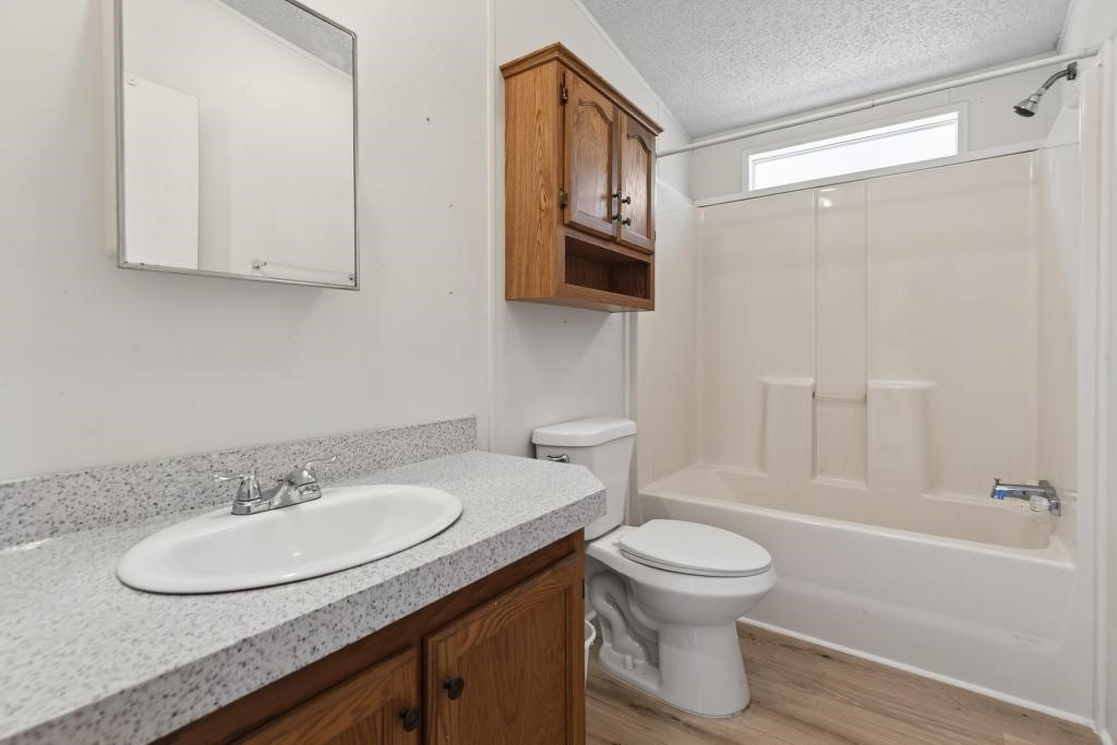 54059 Charles Street Callahan, FL 32011 - Photo 25 of 50 a bathroom with a granite countertop sink toilet a mirror and shower