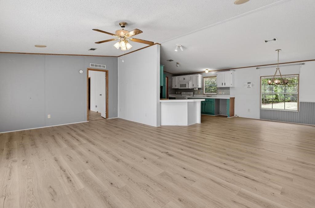 54059 Charles Street Callahan, FL 32011 - Photo 10 of 50 a open kitchen with kitchen island a refrigerator stove a sink and dishwasher with wooden floor