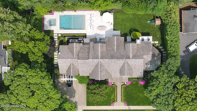 an aerial view of a house with lots of trees and flowers