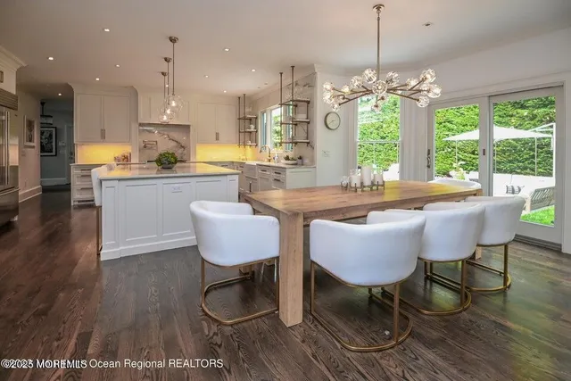 a dining room with furniture a chandelier and wooden floor