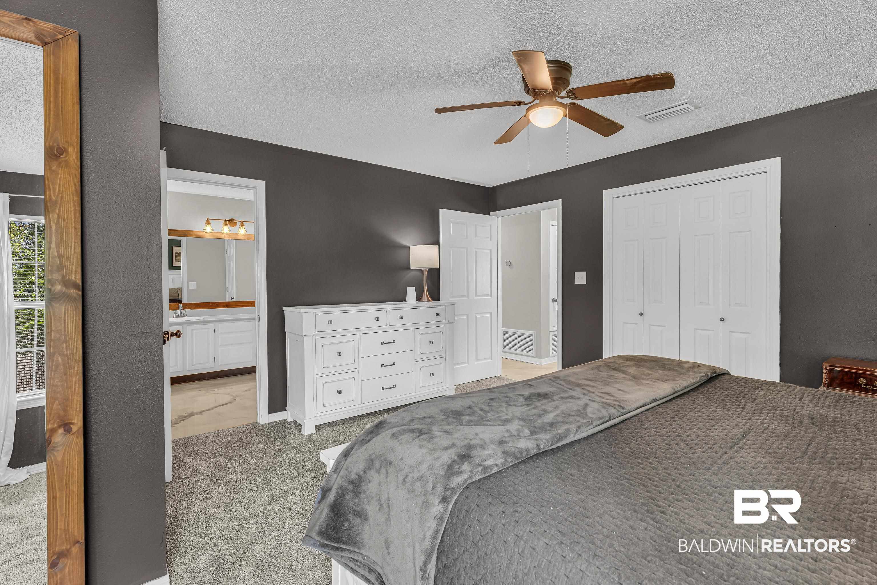 23214 Rochelle Loop Robertsdale, AL 36567 - Photo 23 of 27 Carpeted bedroom with a textured ceiling, a closet, a ceiling fan, and connected bathroom