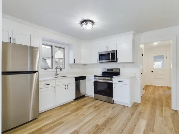 a kitchen with granite countertop a refrigerator stove top oven and sink