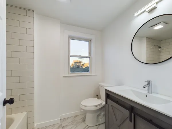 a bathroom with a toilet a sink and mirror