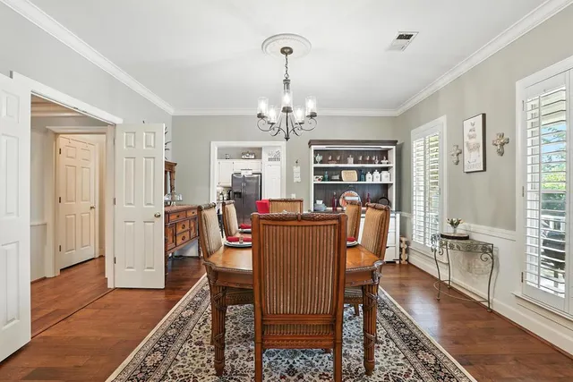 a kitchen with stainless steel appliances kitchen island granite countertop a table chairs sink and cabinets