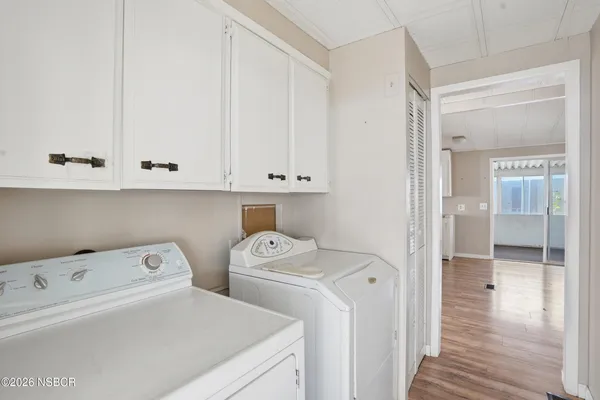 a view of washer and dryer with bathroom in the background