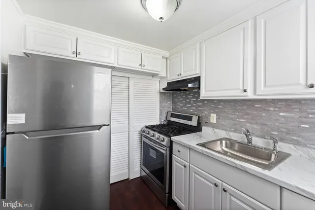 a kitchen with a refrigerator sink and cabinets