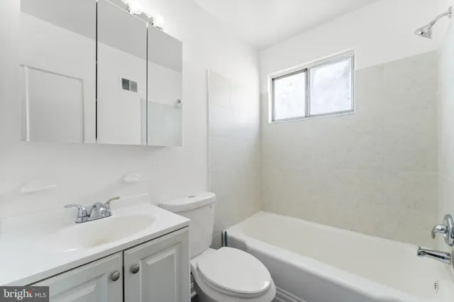 a bathroom with a sink toilet vanity and bathtub
