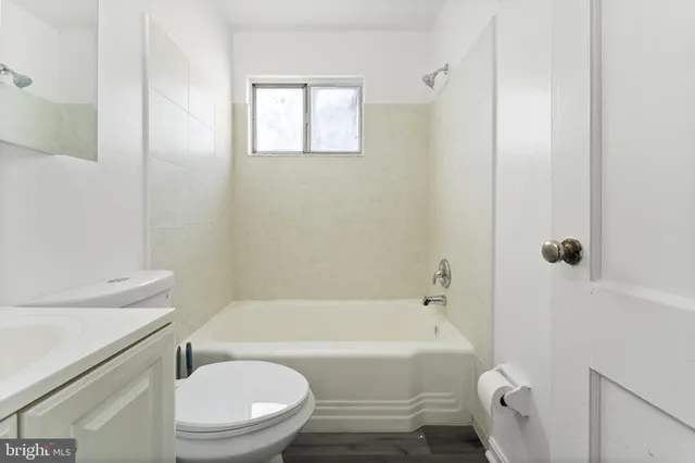 a bathroom with a toilet and a bath tub