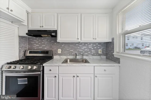 a kitchen with stainless steel appliances granite countertop a sink stove and cabinets