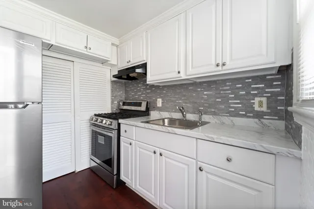 a kitchen with stainless steel appliances granite countertop white cabinets sink and dishwasher