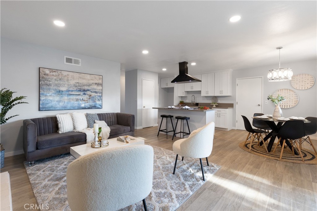 a living room with furniture a rug and a dining table