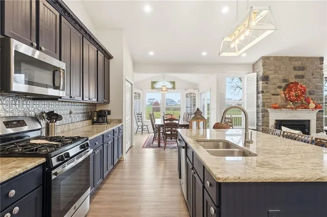 a kitchen with stainless steel appliances granite countertop a sink stove and cabinets