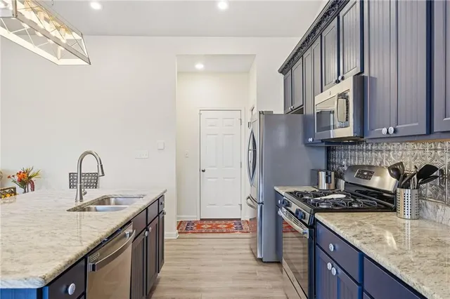 a kitchen with stainless steel appliances granite countertop a sink stove and refrigerator