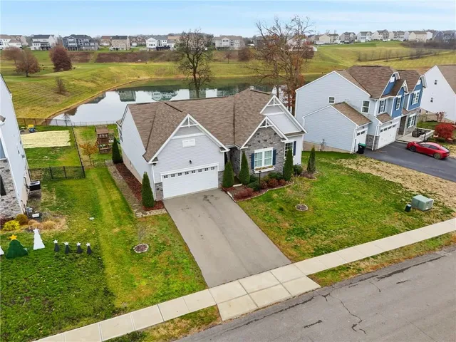 an aerial view of a house with a garden and lake view