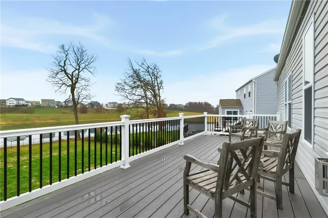 a view of a balcony with chairs and wooden fence
