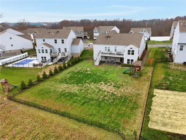 an aerial view of a house with a garden and lake view