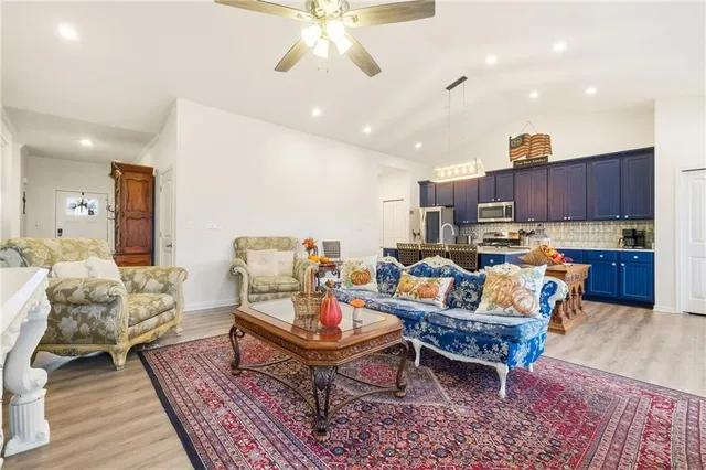 a living room with furniture kitchen view and a wooden floor