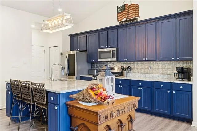 a kitchen with stainless steel appliances wooden cabinets granite counter tops and chairs