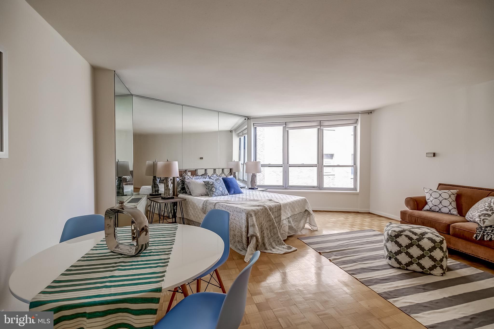 a living room with furniture a wooden floor and a large window