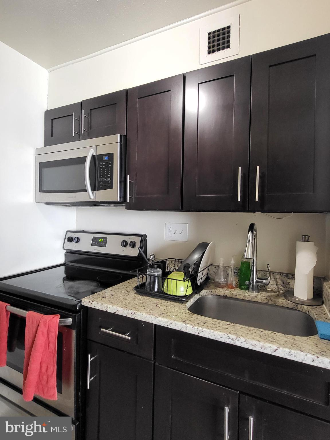 224-30 West Rittenhouse Square, Unit 2604 Philadelphia, PA 19103 - Photo 7 of 21 a kitchen with a sink a stove and cabinets