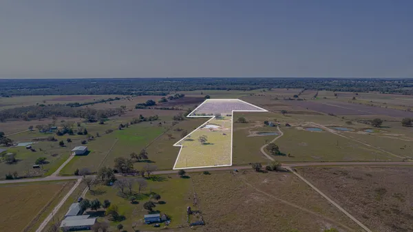 an aerial view of a house with a backyard