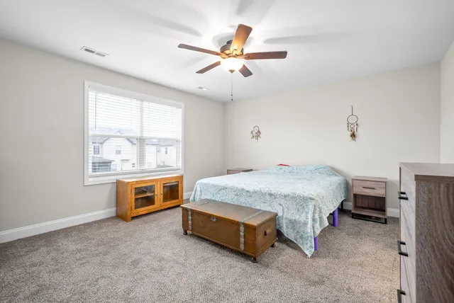 a spacious bedroom with a bed and window