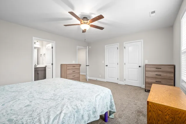 a spacious bedroom with a bed and a dresser