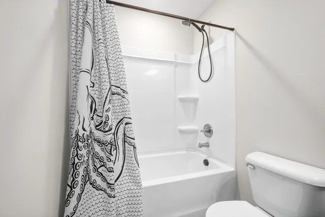 a bathroom with a shower curtain and a white door