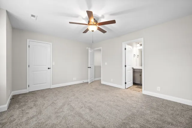an empty room with closet and ceiling fan