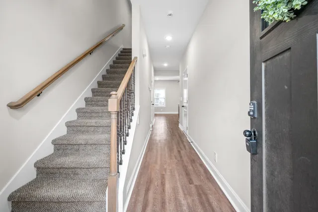 a view of a hallway with wooden floor and entryway