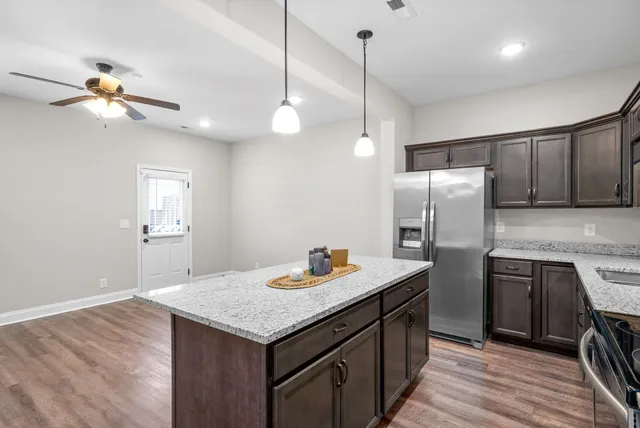 a kitchen with refrigerator cabinets and wooden floor