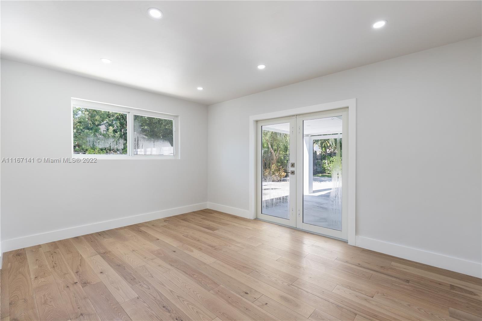 4730 Bay Point Road Miami, FL 33137 - Photo 12 of 25 an empty room with wooden floor and windows