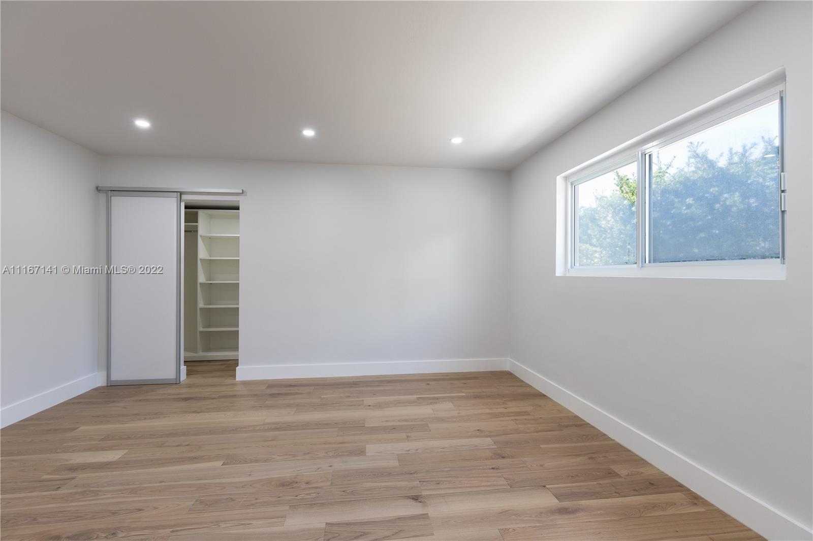 4730 Bay Point Road Miami, FL 33137 - Photo 14 of 25 an empty room with wooden floor and windows