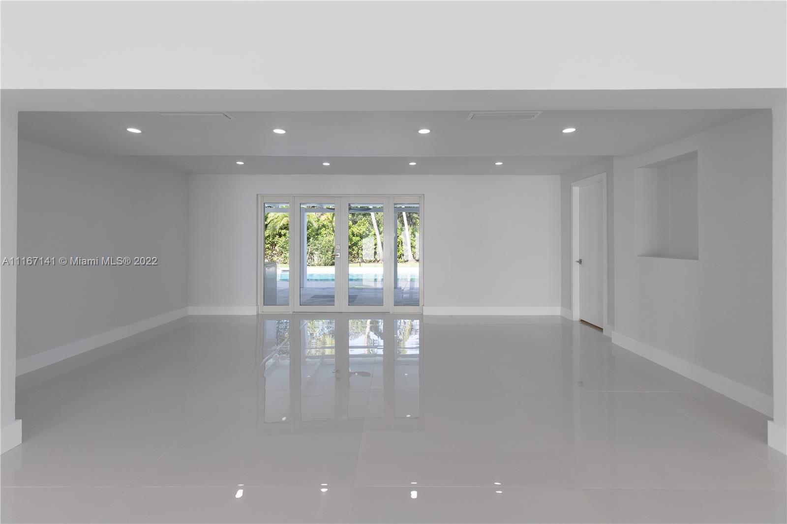 4730 Bay Point Road Miami, FL 33137 - Photo 7 of 25 an empty room with wooden floor and windows