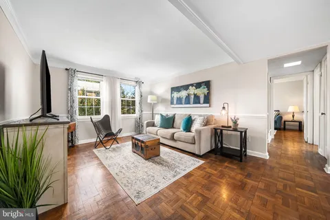 a living room with furniture wooden floor and a large window