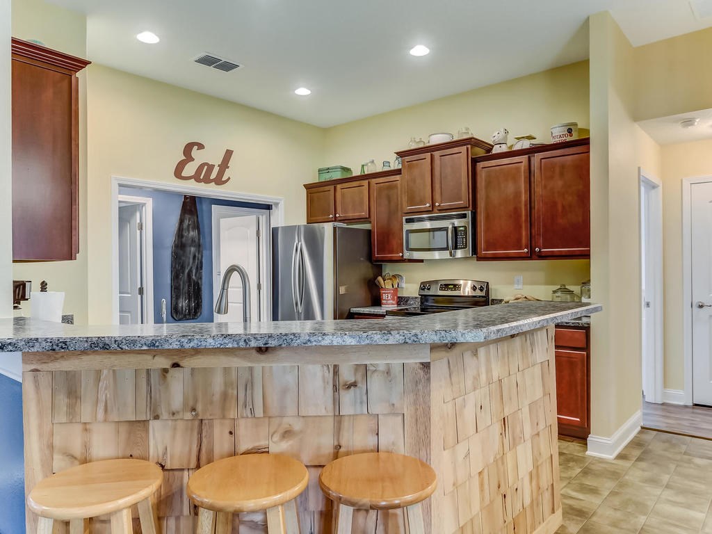 88358 Maybourne Road Yulee, FL 32097 - Photo 9 of 27 a kitchen with stainless steel appliances granite countertop a sink and a refrigerator