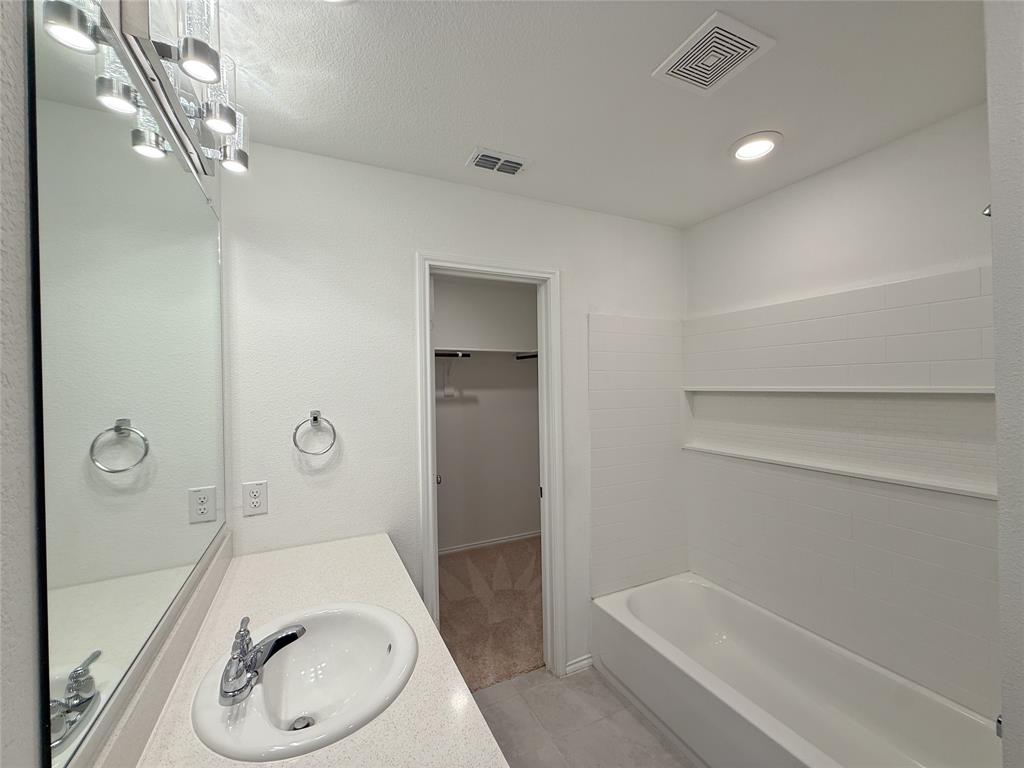 3701 Harper Street Little Elm, TX 75068 - Photo 11 of 26 a bathroom with a granite countertop sink a toilet and shower