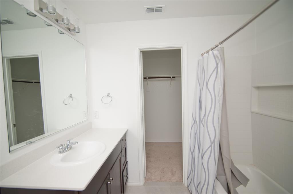 3701 Harper Street Little Elm, TX 75068 - Photo 12 of 26 a bathroom with a sink vanity and shower
