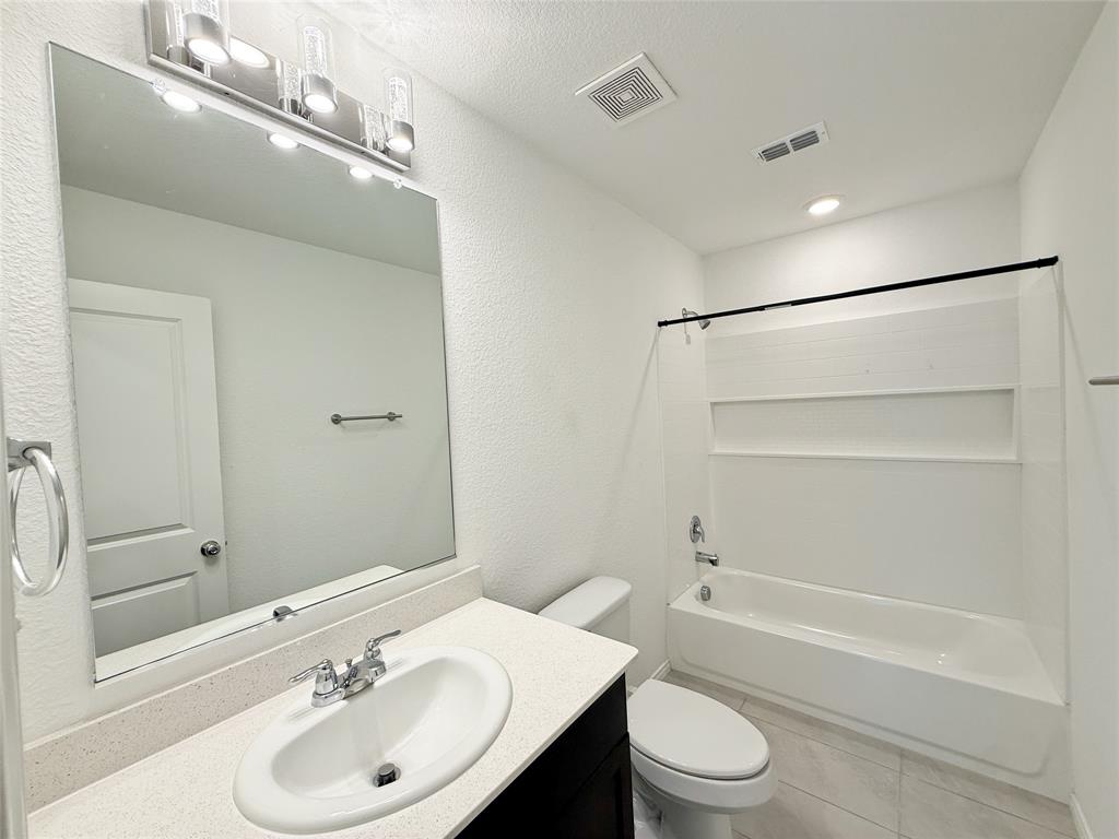 3701 Harper Street Little Elm, TX 75068 - Photo 17 of 26 a bathroom with a sink toilet and shower