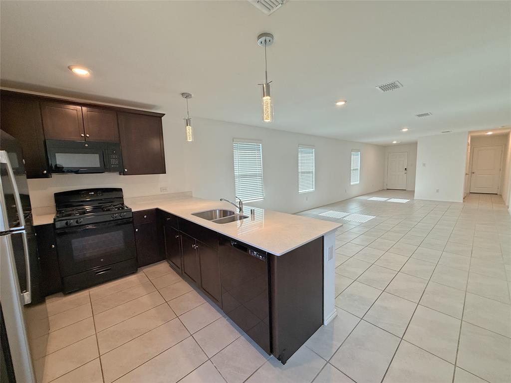 3701 Harper Street Little Elm, TX 75068 - Photo 8 of 26 a kitchen with stainless steel appliances a sink stove and refrigerator