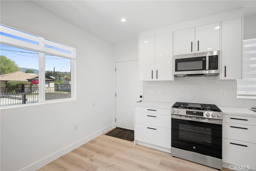 7704 Kyle Street Tujunga, CA 91042 - Photo 3 of 12 a kitchen with stainless steel appliances a stove a microwave and cabinets
