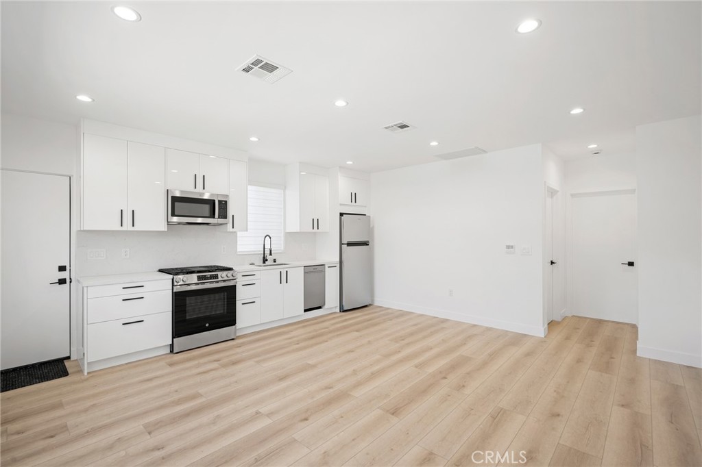 7704 Kyle Street Tujunga, CA 91042 - Photo 5 of 12 a large kitchen with stainless steel appliances granite countertop a stove and a refrigerator
