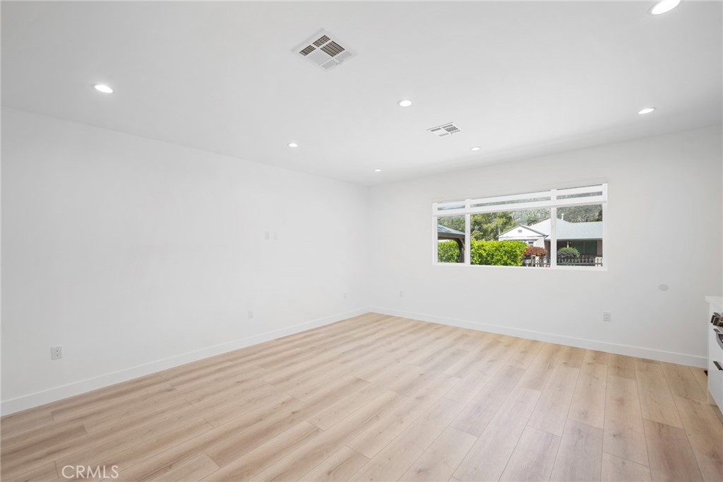 7704 Kyle Street Tujunga, CA 91042 - Photo 7 of 12 an empty room with wooden floor and windows