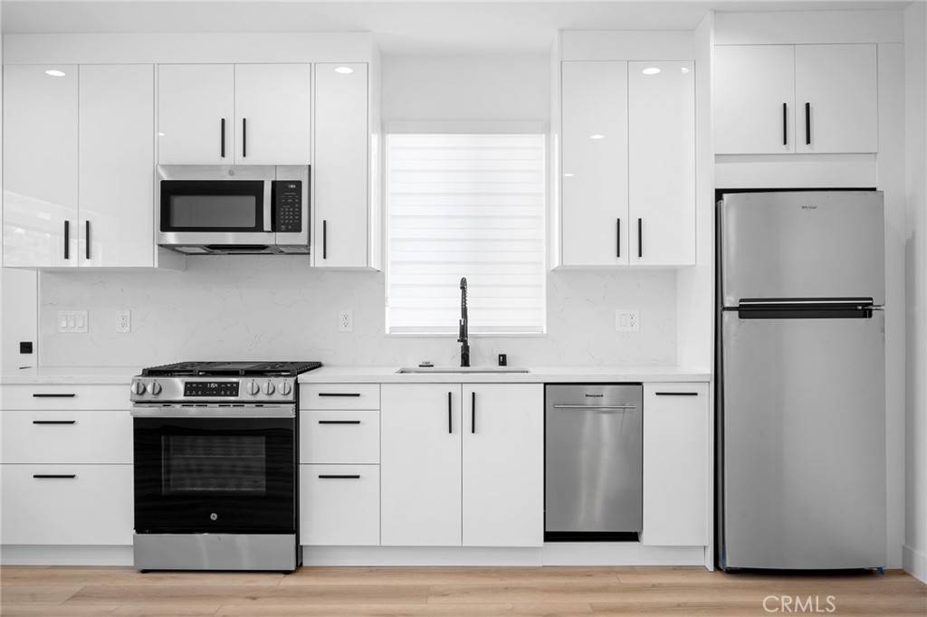 7704 Kyle Street Tujunga, CA 91042 - Photo 8 of 12 a kitchen with stainless steel appliances granite countertop a stove a refrigerator and a sink